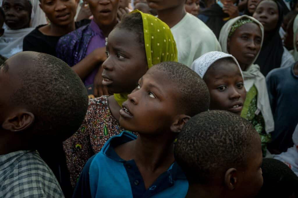 A group of children in africa standing close together and looking off camera
