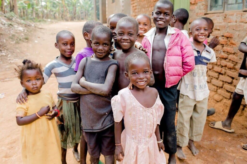 Group of kids in an African village smiling to camera